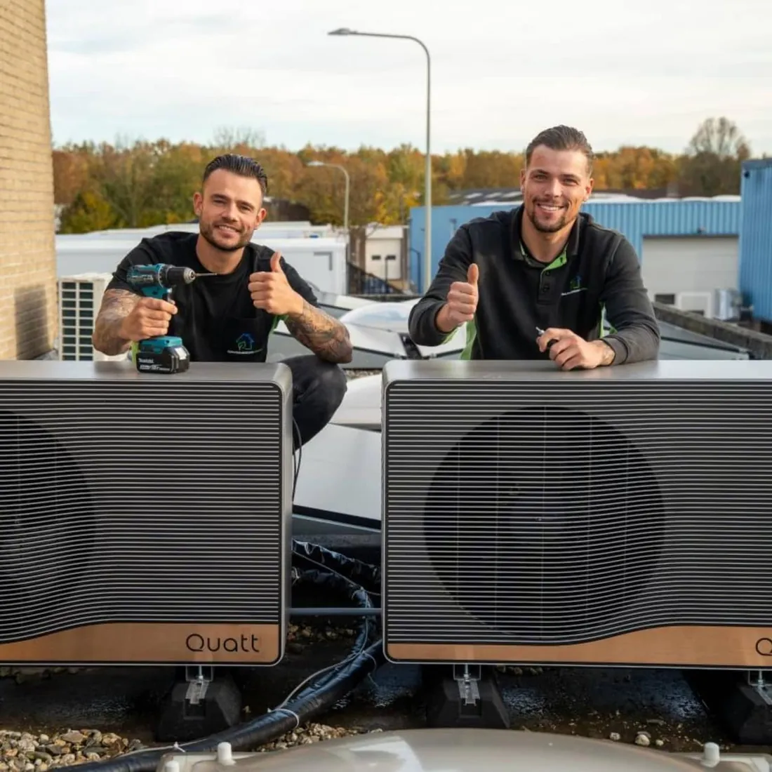 Twee monteurs bij de Quatt warmtepompen op het dak van Keijbeck Opleidingen
